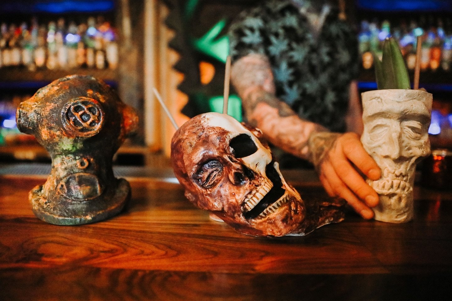 three drinks in spooky cups on a bar counter